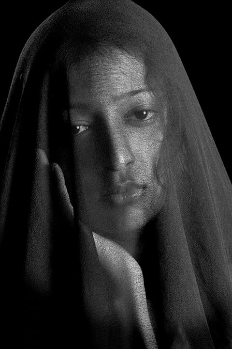 Sheer black veil with raised hand