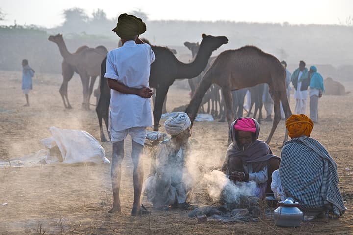 Herders around a smoking campfire at dawn