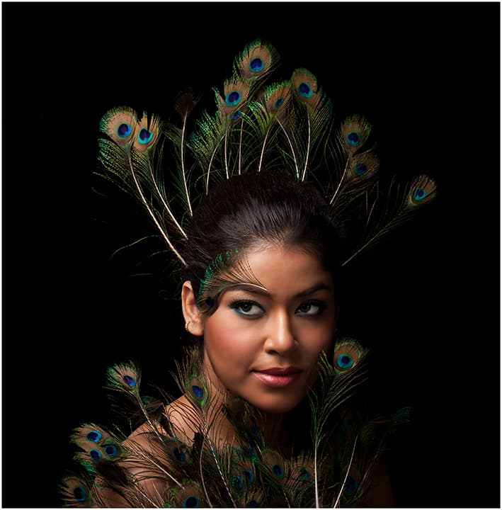 Portrait crowned in fanned peacock feathers